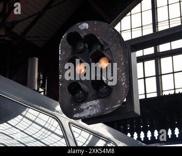 Oranges Licht auf Eisenbahnsemaphor. Oberbahnsignal am Bahnhof. Grungiges Eisenbahnsignal im Zughaus. Stockfoto