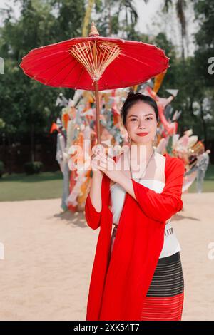 Nordthailändische Chiangmai lanna Leute in traditioneller Kleidung schöne Frauen alte Vintage Kleidung mit Papierschirm im wat Ton kwen. Stockfoto