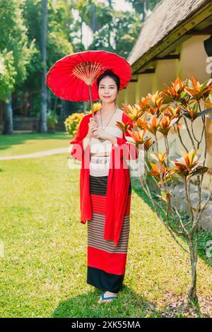 Nordthailändische Chiangmai lanna Leute in traditioneller Kleidung schöne Frauen alte Vintage Kleidung mit Papierschirm im wat Ton kwen. Stockfoto