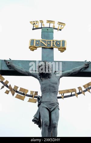 Das Kruzifix und die Bronzeskulptur des Kalvariums auf der Karlsbrücke, Prag, Nahaufnahme von Christus am Kreuz, mit Hebräisch, Worten, heilig heilig Stockfoto