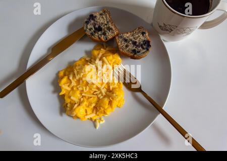 Rührei, Blaubeermuffin, schwarzer Kaffee Stockfoto