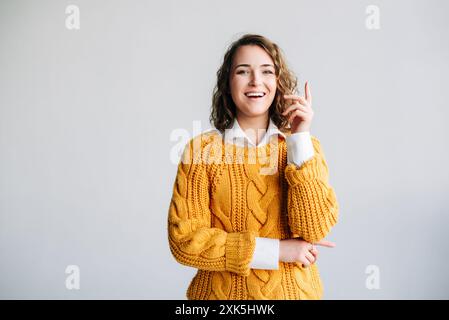 Young Woman Student hat Eureka-Moment – begeistert, clever, zeigt mit neuer Idee auf – Wow Promotion Offer Presentation – konzeptionelles Bild der Innovation Stockfoto