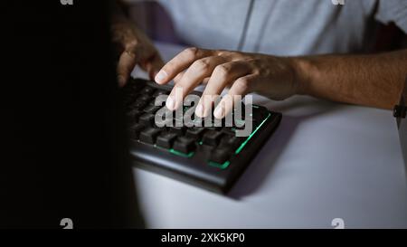 Nahaufnahme eines Mannes Hände, die auf einer beleuchteten mechanischen Tastatur in einem dunklen Raum tippen. Stockfoto