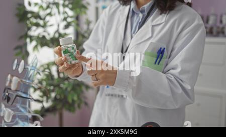 Eine Apothekerin in einem weißen Mantel, die eine Flasche grüne und weiße Pillen in einer Apotheke mit verschiedenen Brillen zeigt. Stockfoto