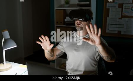 Ein bärtiger junger Mann erlebt virtuelle Realität in einem modernen Büroumfeld und schafft ein Gefühl von Immersion und Innovation. Stockfoto