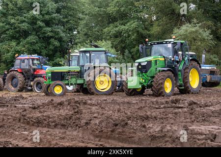 Ballymena, Nordirland - 20. Juli 2024: Rallye mit Traktoren und Dampflokomotiven, legendärer John Deere 3350 in Grün und Gelb auf schlammigem Feld. Stockfoto