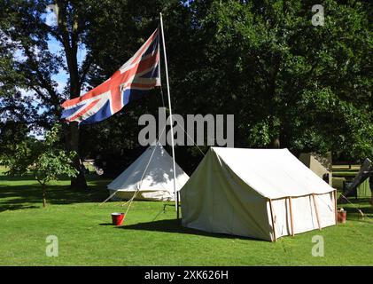 Alte Zelte und die Flagge der British Union auf dem Pol. Alte Zelte und Flagge der British Union auf Stangenbäumen im Hintergrund Stockfoto