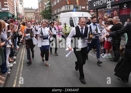Die Leute nehmen am Soho Kellner's Race auf dem Soho Village Fete im Zentrum von London Teil. Bilddatum: Sonntag, 21. Juli 2024. Stockfoto
