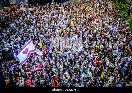 Tel Aviv, Israel. Juli 2024. Israelische Demonstranten schwenken ihre Nationalflagge und eine rosa Flagge mit einem hart während einer Protestkundgebung in Tel Aviv am Samstag, den 20. Juli 2024. Regierungsfeindliche Demonstranten versammelten sich am Samstagabend in den Städten Israels und forderten Premierminister Benjamin Netanjahu auf, am nächsten Tag nicht zu einem geplanten Besuch in Washington zu reisen, bis er zuerst ein Abkommen mit der Hamas unterzeichnet hat, um die Rückkehr der Geisel aus Gaza zu erleichtern. Quelle: Eyal Warshavsky/Alamy Live News Stockfoto