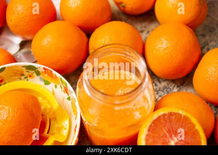 Ein Blick auf mehrere cara cara Orangen und ein Glas Orangensaft. Stockfoto