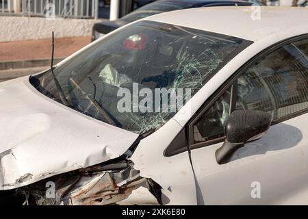 Nahaufnahme des Fahrzeugs mit erheblichen Schäden an der Front nach einem Zusammenstoß, wobei die zersplitterte Windschutzscheibe und die verformte Motorhaube hervorgehoben werden. Perfekt für Inhalte auf der Straße Stockfoto