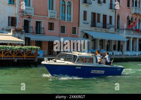 Venedig, Italien - 4. Juni 2024: Polizeiboot am Kanal von Venedig. Offiziere sitzen am Rand des Bootes. Sonniger Tag im Sommer. Stockfoto