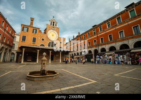 Venedig, Italien - 03. Juni 2024: Trinkbrunnen in der Straße Ruga dei Oresi. Chiesa di San Giacomo di Rialto im Hintergrund. Sonniger Tag, bewölkter Himmel. Stockfoto