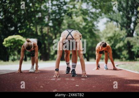 Eine Gruppe von Athleten macht sich bereit, auf einer Outdoor-Strecke in einem Park zu laufen Stockfoto