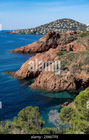 Blick auf die Corniche d’Or oder Corniche de l’Esterel wunderschöne Küstenstraße, kristallblaues Meer und Himmel kombiniert mit rötlicher Farbe des Massif de l’Est Stockfoto