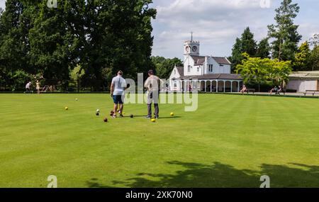 Ein sonniger Tag auf dem Bowling Green im South Park, Darlington, England, Großbritannien, mit zwei Männern und zwei Frauen, die Bowls spielen Stockfoto