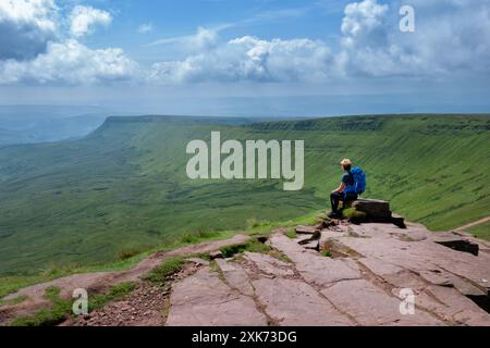 Brecon Beacons Wales. Eine einsame weibliche Walkerin sitzt und ruht auf dem Gipfel des Corn du. Sie nimmt die Sicht vom Gipfel nach Südwales ein Stockfoto