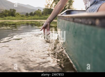Entspannende Kanufahrt, eine Frau, die an einem angenehmen Sommertag auf dem malerischen See Kanu fährt. Naturliebhaber und aktive Lebenskonzepte. Stockfoto
