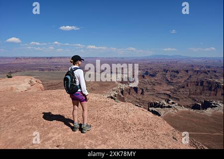 Frau wandert auf dem White Rim Overlook Trail im Canyonlands National Park, Utah an einem klaren, sonnigen Sommernachmittag. Stockfoto