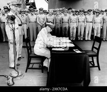 US-General Douglas MacArthur saß am Schreibtisch während der offiziellen Kapitulationszeremonien an Bord der USS Missouri, während Soldaten auf sie schauen, Tokyo Bay, Japan, US Army Signal Corps, 2. September 1945 Stockfoto