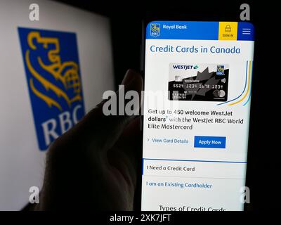 Person mit Smartphone und Webseite des kanadischen Finanzunternehmens Royal Bank of Canada (RBC) mit Logo. Konzentrieren Sie sich auf die Mitte des Telefondisplays. Stockfoto