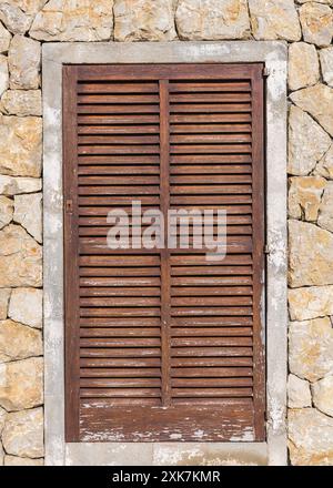 Hölzerne Tür in eine Mauer aus Stein Stockfoto