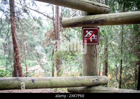 Ein Warnschild am hölzernen Geländer, über das hinüberklettern ist nicht erlaubt. Stockfoto