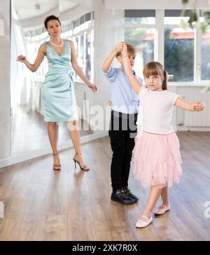 Junge und Mädchen trainieren zu zweit, um während des Kurses zeitgemäße, lebhafte Hektik zu tanzen. Stockfoto