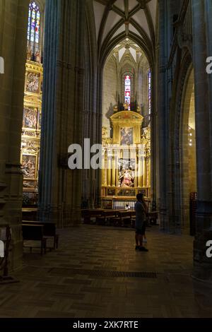 Astorga, Spanien - 4. Juni 2023: Allein in der Kathedrale Santa Maria de Astorga bewundert ein Besucher den goldenen Altar, während das Sonnenlicht durch die St. Stockfoto