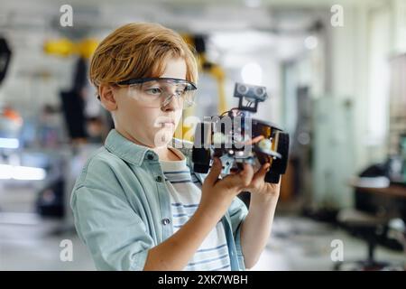 Porträt eines Schülers, der ein Roboterauto im Robotikclub der Schule baut. Kinder, die Robotik in der Grundschule lernen. Wissenschaft für Kinder. Stockfoto