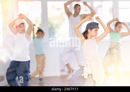 Ein junges Mädchen, das Hip-Hop-Choreographie mit Kollegen und Lehrer praktiziert Stockfoto