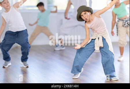 Ein junges Mädchen, das Hip-Hop-Choreographie mit Kollegen und Lehrer praktiziert Stockfoto