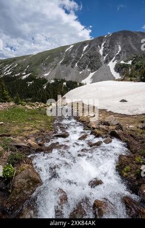 Schmelzender Gletscher auf dem Lake Isabelle Trail in Indian Peaks Wilderness, Colorado, unter sonnigen Sommerwolken. Stockfoto