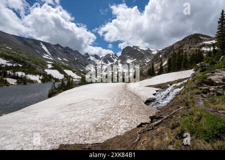 Schmelzender Gletscher auf dem Lake Isabelle Trail in Indian Peaks Wilderness, Colorado, unter sonnigen Sommerwolken. Stockfoto