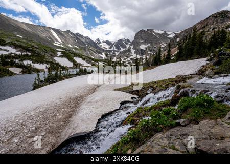 Schmelzender Gletscher auf dem Lake Isabelle Trail in Indian Peaks Wilderness, Colorado, unter sonnigen Sommerwolken. Stockfoto