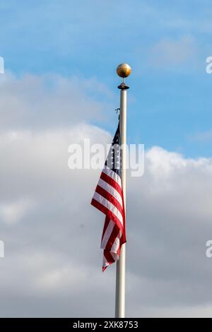 Eine rot-weiß-blau gefärbte Flagge der Vereinigten Staaten von Amerika, die an einem Metallfahnenmast hängt. Kein Wind und die Fahne hängt. Stockfoto