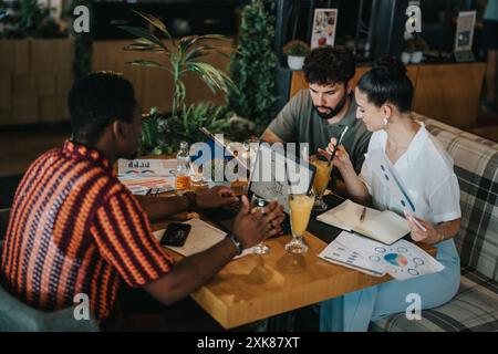 Ein vielfältiges Team arbeitet während eines Meetings an einer Café-Bar zusammen Stockfoto