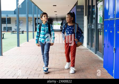 Birassische Jungen und Mädchen gehen an Schließfächern in der Schule vorbei Stockfoto