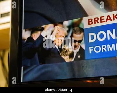 London, UK - 14. Juli 2024: Die Miniaturansicht von Nachrichten im Live-Fernsehen zeigt Trump inmitten von Chaos und Schüssen, hebt seine Faust und projiziert ein charakteristisches Bild von Trotz Stockfoto
