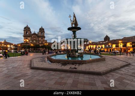 Cusco, Peru: Der Kaiser des INCO bestieg den Brunnen mitten auf der plaza de armas in der Kolonialzeit von Cusco in der Abenddämmerung mit der Kirche der Gesellschaft der Jes Stockfoto