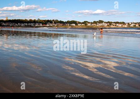 Der Himmel spiegelt sich im flachen, welligen Wasser eines Strandes Stockfoto