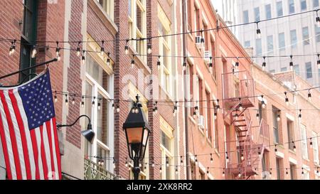 New York City Gebäudearchitektur. Wohnhaus außen. Immobilien, US-Flagge. Typische rote Ziegelfassade. Manhattan Downtown Financial District, Stone Street, FIDI. Fluchtleiter Stockfoto