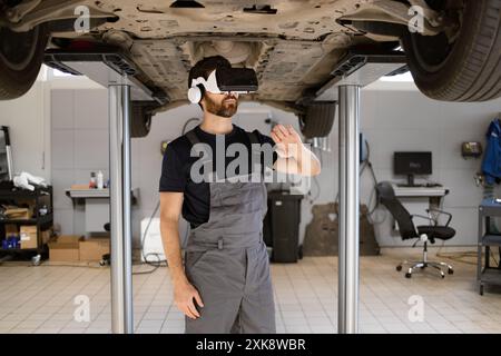 Mechaniker, der das Auto mit virtueller Brille in einer modernen Werkstatt untersucht Stockfoto