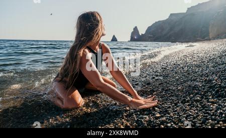 Frau in schwarzem Badeanzug spielt im Meer Stockfoto