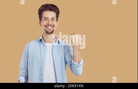 Glücklicher Mann, der mit dem Finger auf den Kopierbereich für Werbeartikel zeigt, der das Angebot für ein Rabattangebot präsentiert Stockfoto