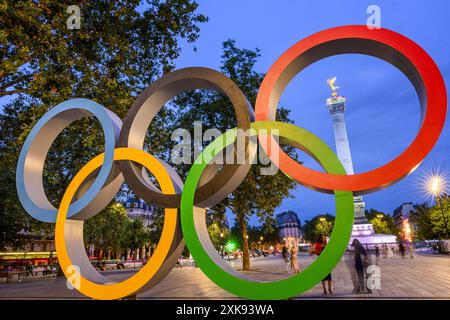 FRANKREICH. PARIS (75) (4. BEZIRK) BASTILLE PLATZ. DIE OLYMPISCHEN RINGE, DIE AUF DEM PLATZ FÜR DIE OLYMPISCHEN SPIELE 2024 IN PARIS INSTALLIERT WURDEN. IM HINTERGRUND WIRD DIE Stockfoto