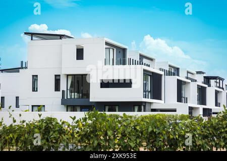 Brandneue weiße Wohngebäude in Phuket Thailand. Moderne Wohnarchitektur mit grünen Bäumen und Zaun. Duplex-Apartment. Garden Apartment Stockfoto