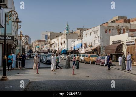 Das geschäftige Marktviertel und die saudischen Menschen auf den Straßen von Dschidda (Jedda) in Saudi-Arabien während der Mittagszeit. Stockfoto