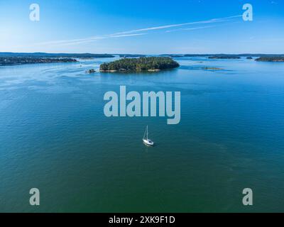 Ein Segelboot im Stockholmer Archipel mit seinen vielen Inseln, Kajaks und Motorbooten, die vorbeifahren. Sommer. Typisch schwedische Landschaften Stockfoto