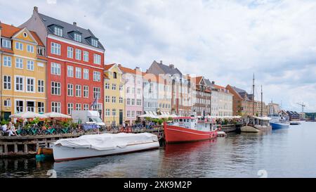 Kopenhagen Dänemark 21. Juli 2024, Ein Blick auf die Uferpromenade in Kopenhagen, Dänemark, mit farbenfrohen Gebäuden und Booten, mit Menschen, die die Natur genießen. Stockfoto